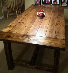 a wooden table with pictures on the wall behind it