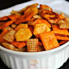 a white bowl filled with cheetos sitting on top of a table