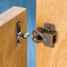 a close up of a wooden door with a metal latch on the front and side