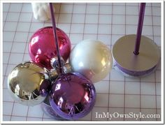 several ornaments are on the table with purple and white balls