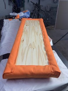 an orange and white mattress sitting on top of a piece of paper next to a bike