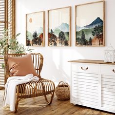 a room with three paintings hanging on the wall and a chair in front of it