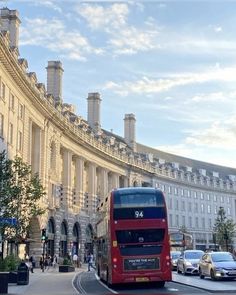 a red double decker bus driving down a street