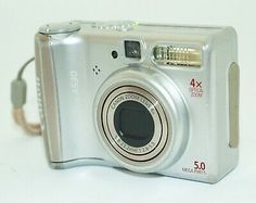 a silver camera sitting on top of a white table