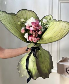 a person holding a bouquet of flowers in their hand