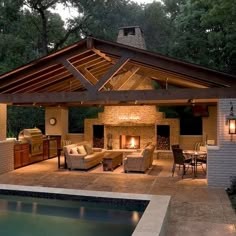 an outdoor living area next to a swimming pool with furniture and lights on the patio