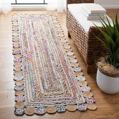 a large rug is on the floor next to a potted plant and wicker basket