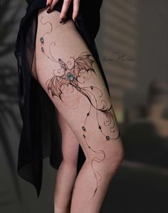 a woman's thigh with tattoos on her legs and the bottom part of her leg