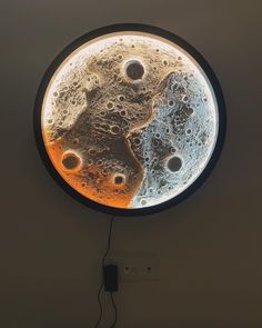 a clock that is hanging on the wall with water and air bubbles in front of it