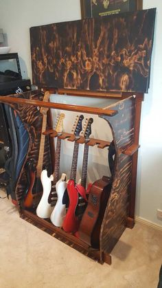 guitars are lined up in a rack on the floor next to a guitar case and other musical instruments