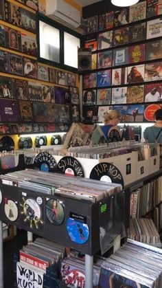 a record store with records and cds on the shelves, in front of a wall full of cd's