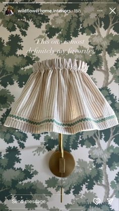 a lamp shade on a wall in front of a forest print background with the words, this one must definitely be my favorite