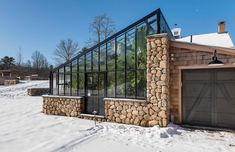 a stone and glass house in the snow