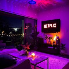 a living room with purple lighting and a television on the wall that reads'netflix '