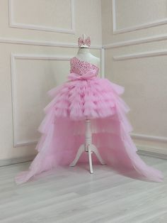 Make your little one's special day even more magical with our stunning Pink Tulle Train Birthday Girl Dress! This custom fluffy tutu dress is designed to turn heads and make your toddler feel like a true princess. Features: Elegant Design: This dress features a beautiful pink tulle train that adds a touch of grandeur and elegance. Perfect for making a grand entrance at any birthday party or special event. Custom Fit: Each dress is handmade to ensure a perfect fit for your toddler. Available in a Birthday Gown With Ruffles And Tulle, Birthday Gown With Ruffles And Tulle Material, Birthday Gown With Tulle Ruffles, Birthday Tulle Gown With Ruffles, Whimsical Ruffled Tutu Dress For Wedding, Whimsical Tulle Birthday Dress, Whimsical Tulle Tutu Dress For Birthdays, Whimsical Tulle Tutu Dress For Birthday, Whimsical Ruffled Tutu Dress For Pageants