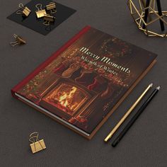 a book with christmas decorations on it next to pencils and other items in front of it