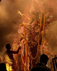 a man standing next to a giant statue in the middle of a stage filled with people