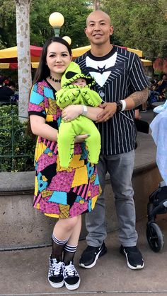 a man and woman standing next to each other holding a stuffed animal in their arms