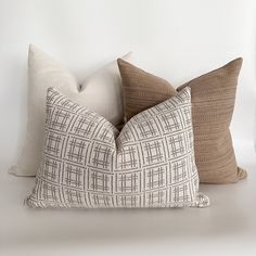 three pillows sitting next to each other on a white surface