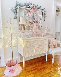 a white dresser sitting on top of a hard wood floor next to a christmas tree