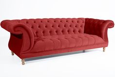 a red couch sitting on top of a white floor