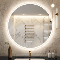 a bathroom sink with a round mirror above it and gold faucets on the wall