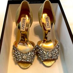 a pair of gold high heeled shoes in a box