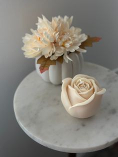 two white vases with flowers on a marble table