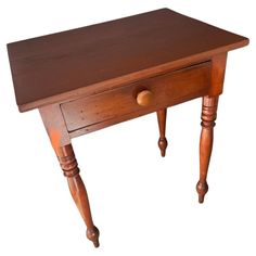 a small wooden table with two drawers on one side and an open drawer on the other