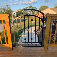 an iron gate is open on a wooden deck