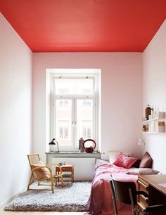 a bedroom with pink walls and wooden floors