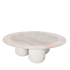 a white and pink marbled table with two round pedestals on each side, in front of a white background