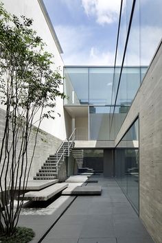 an empty courtyard with steps leading up to the building's second floor and stairs