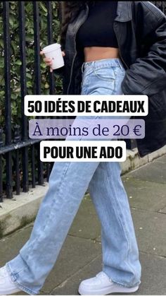 a woman walking down the street in jeans and sneakers