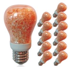 a light bulb filled with lots of small orange beads next to it's bulbs