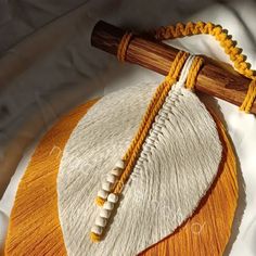 an orange and white round object with two wooden sticks on it's side, sitting on a white surface