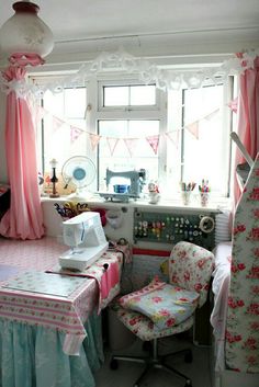 a sewing machine sitting on top of a table next to a chair in front of a window