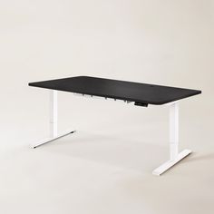 a black and white computer desk with two legs on each side, in front of a gray background