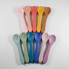 a group of spoons sitting next to each other on top of a white wall