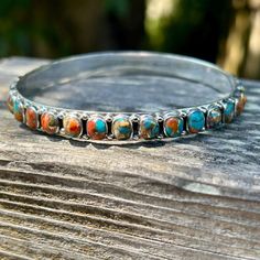 Spiny Oyster never goes out of style because it's just so darn pretty.  It looks like a sunset with it's turquoise blue skies and yellows and oranges like the sun.  A bangle adds that perfect touch to your turquoise layering stack.  This bangle is a hard find because the stones go all around the bangle. * Genuine turquoise and spiny oyster  * Sterling Silver (Stamped 925) * Spiny goes all around bangle * Fits wrist best bracelet size 6.5" to 8" * Can be a bit to big for a wrist 6" or smaller * F Spiny Oyster, Southwestern Style, Silver Bangle, Genuine Turquoise, Blue Skies, Silver Bangles, Bracelet Sizes, Turquoise Blue, Sterling Silber