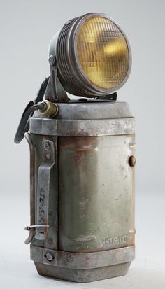 an old metal object with a yellow light on it's head and handlebars