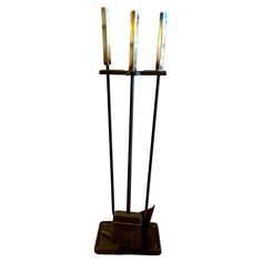 a metal sculpture with three candles on it's base and four sticks sticking out of the top