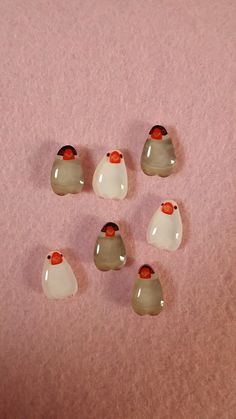 six small white and grey birds on a pink surface