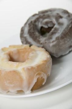 two glazed donuts on a white plate