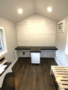 an empty room with white walls and wood flooring