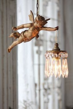 an angel figurine hanging from a chandelier