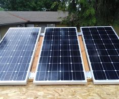 three solar panels sitting on top of a roof