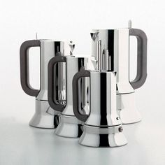 two stainless steel french press coffee makers sitting side by side on a white table top