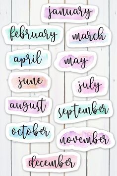 months of the year stickers with watercolor paint on white wooden planks background