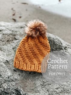 a knitted hat with a pom - pom sits on top of a rock